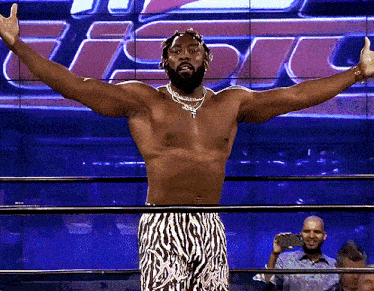 a shirtless wrestler in zebra print shorts is standing in a ring