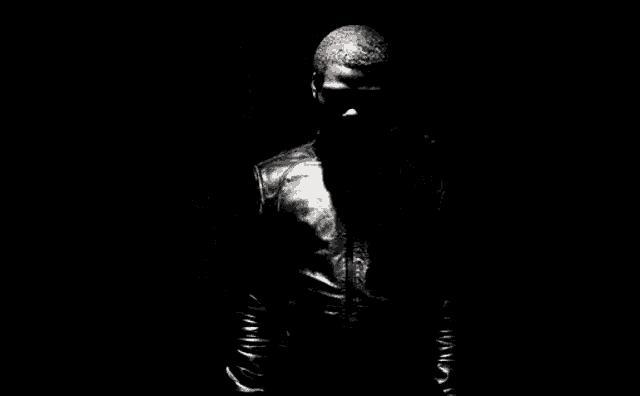 two men in leather jackets are standing next to each other in the dark .