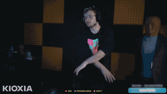a man wearing a nike shirt is dancing in front of a black wall
