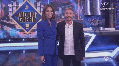 two people standing in front of a sign that says el hormi guero