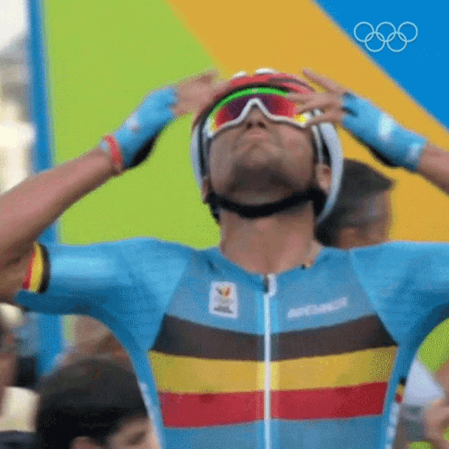 a man wearing a helmet , goggles and gloves is looking up at the sky .