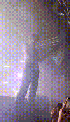 a blurry picture of a person standing on a stage in front of a crowd