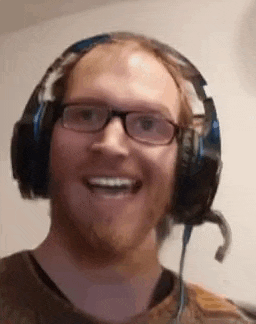 a man with a beard and glasses is wearing headphones and a microphone .