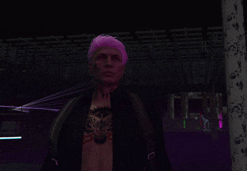 a man with pink hair and a tattoo on his chest stands in a dark room
