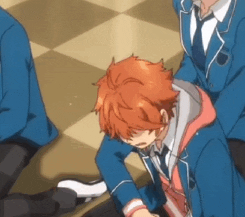 a man in a suit and tie is sitting on the floor .