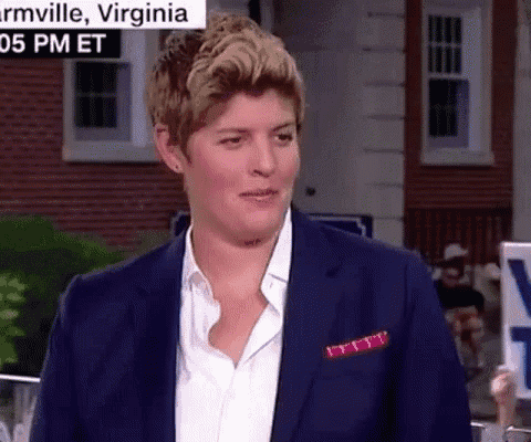 a woman in a blue suit is standing in front of a sign that says virginia