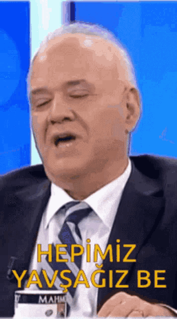 a man wearing a suit and tie says hepimiz yavsagiza be