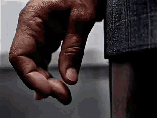 a close up of a man 's hand reaching out towards something .
