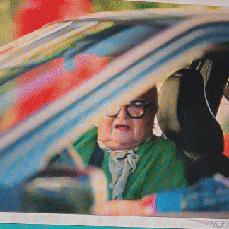 a woman in a green sweater is sitting in a car with the word were on the bottom right