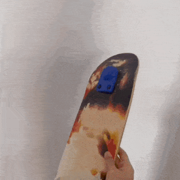a person is holding a skateboard that has a blue sticker on it