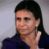 a woman with long black hair is making a funny face and holding her hand to her face .