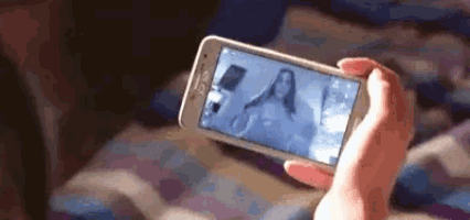 a person is holding a cell phone with a picture of a woman on it .