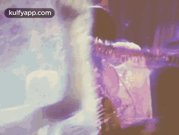 a close up of a person playing a guitar in a purple background