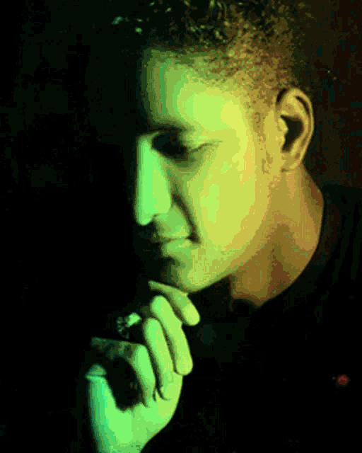 a close up of a man 's face with a yellow and green background
