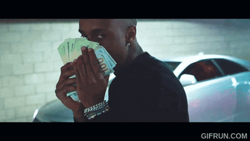 a man holding a bunch of money in front of his face