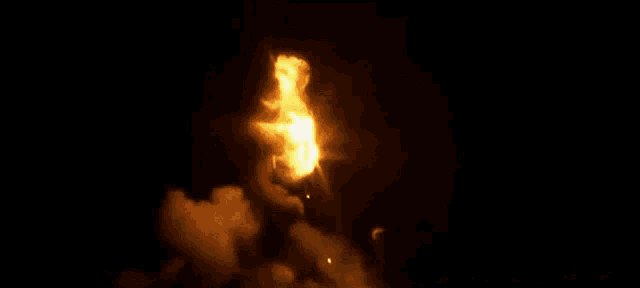 a rocket is being launched at night with a lot of smoke coming out of it