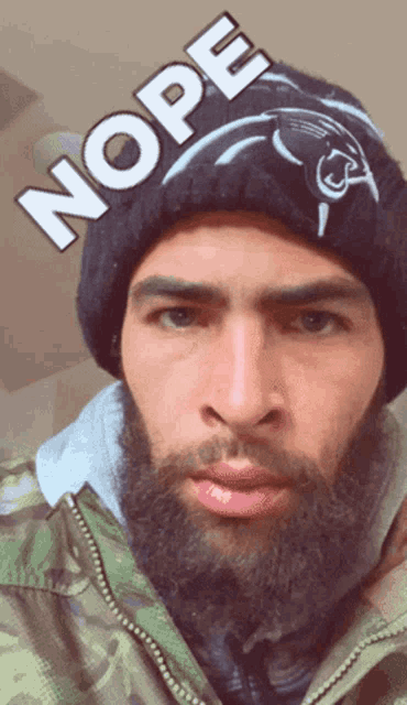 a man with a beard is wearing a hat that says nope