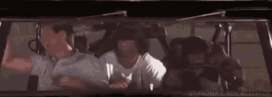 a group of men are sitting in a car and looking at each other .