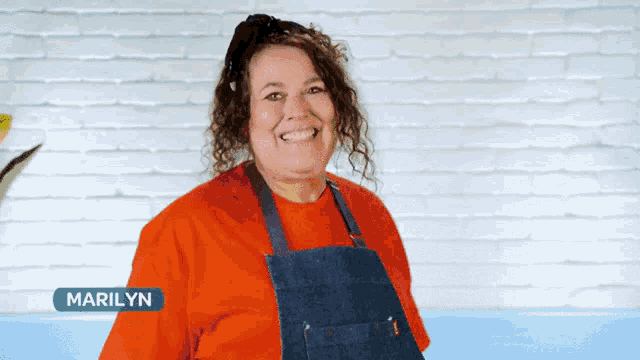 a woman wearing a red shirt and a blue apron is called marilyn