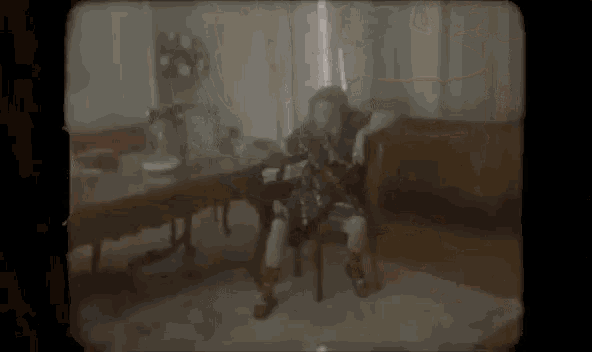 a blurred image of a person sitting in a chair in a living room