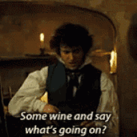 a man in a vest and tie is holding a bottle of wine and saying some wine and say what 's going on .