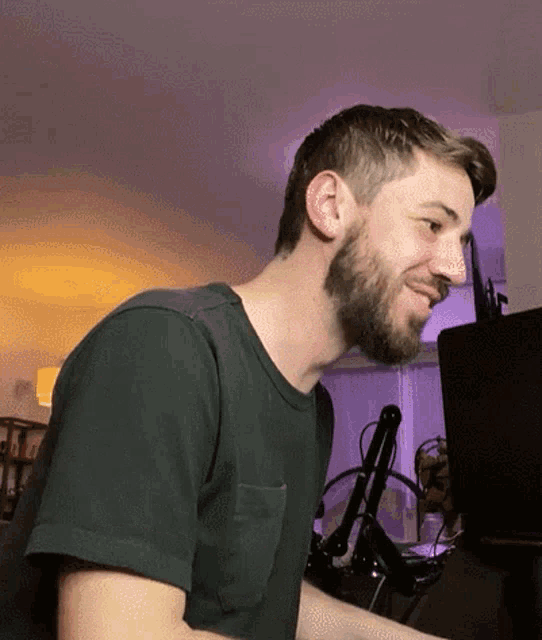 a man with a beard and a black shirt is smiling