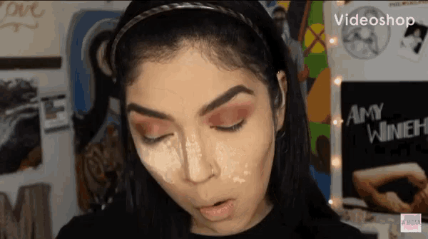 a woman 's face is shown in front of a poster that says amy winehouse