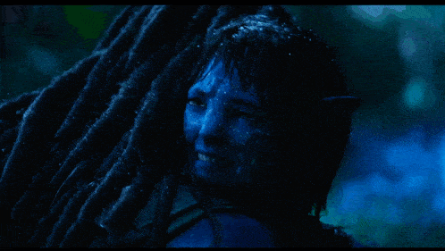 a woman with blue paint on her face is hugging another woman