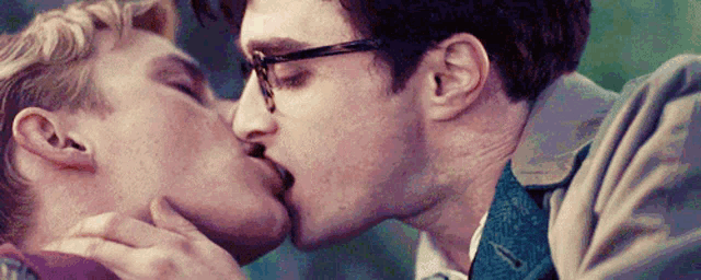 two men are kissing each other on the cheek .
