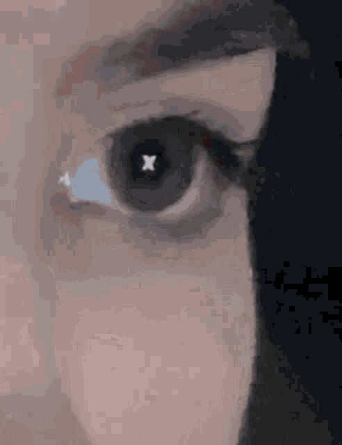 a close up of a woman 's eye with a white x in it