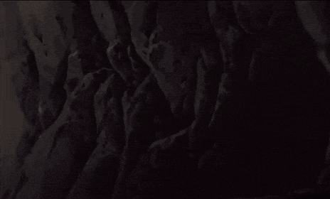 a girl with green hair is sitting in the dark