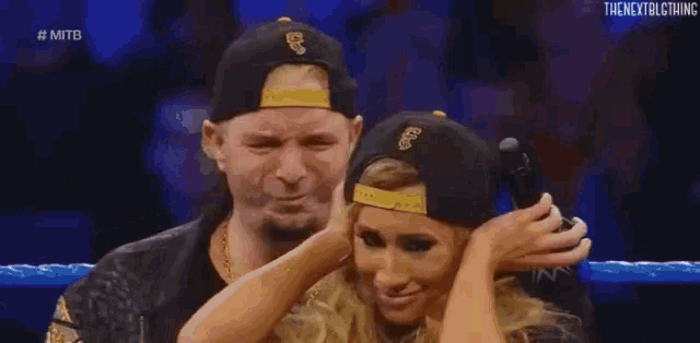 a man and a woman are standing next to each other in a ring .
