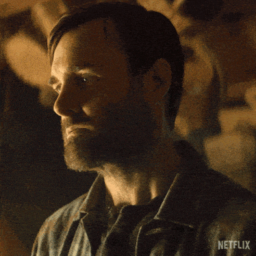 a man with a beard and a netflix logo on his shirt