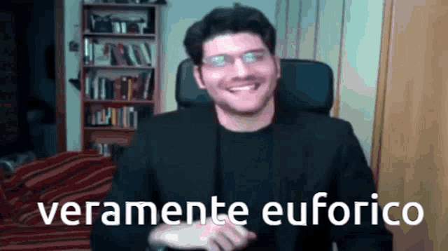 a man in a suit and glasses is smiling and the words veramente euforico are behind him