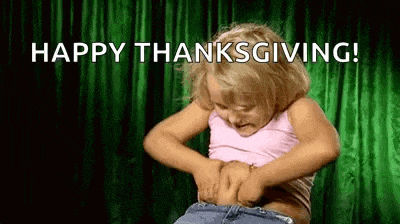 a little girl is holding her belly and says `` happy thanksgiving ! ''