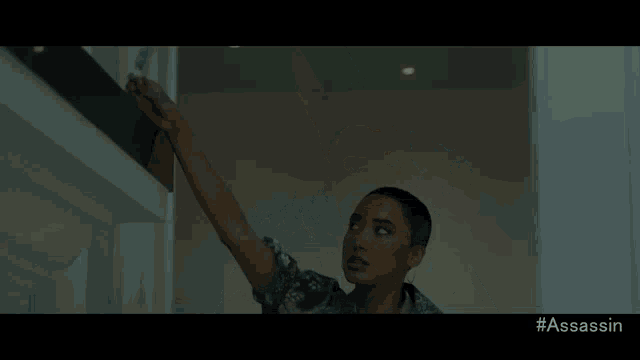 a woman is reaching for something in a dark room with the hashtag #assassin
