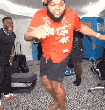 a man with a beard is dancing in a room with other men .
