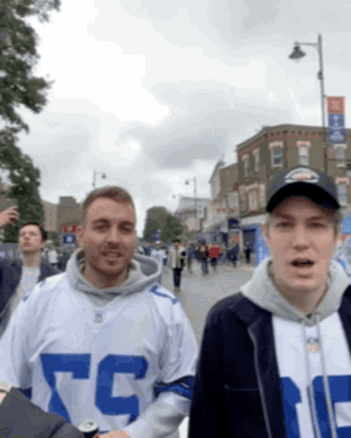 a man wearing a cowboys jersey walking down a street