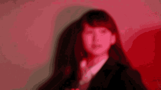 a woman in a suit and tie is smiling in a red light
