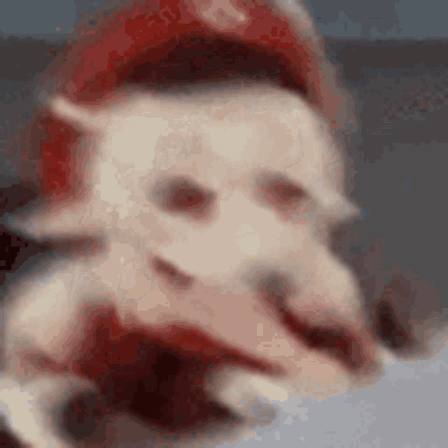 a close up of a cat wearing a red hat and gloves .