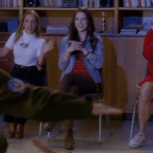 a group of people are sitting in chairs with their legs crossed