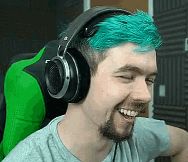 a man with blue hair is wearing headphones