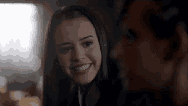 a woman is smiling while looking at a man .