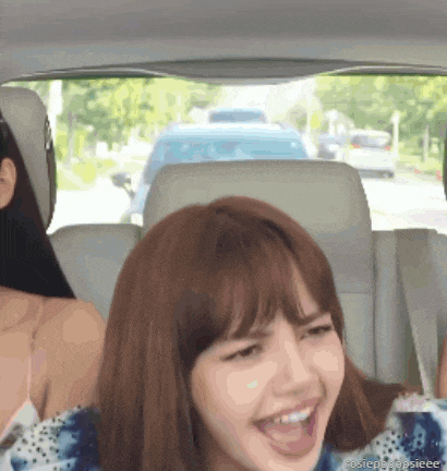a woman sitting in the back seat of a car with her mouth open