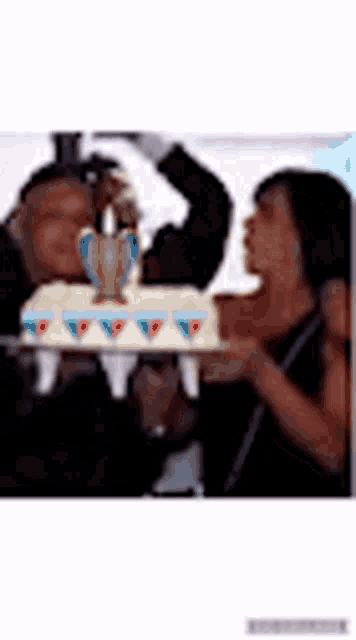 a man and a woman are holding a cake and a trophy .