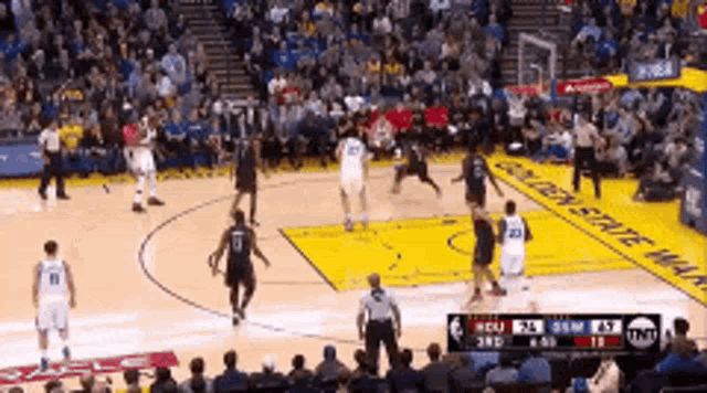 a basketball game is being played in front of a crowd with a sign that says golden state warriors