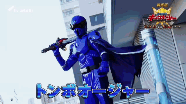 a man in a blue superhero costume holding a gun