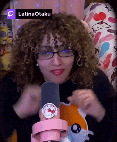 a woman with curly hair wearing glasses and a hello kitty shirt