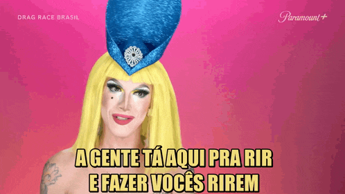 a drag queen wearing a blue hat says agente ta aqui pra rir e fazer voces rirem