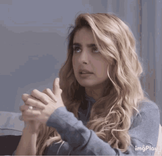 a woman with a ring on her finger is praying with her hands folded in front of her